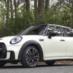 Bijeli Mini Cooper parkiran na cesti