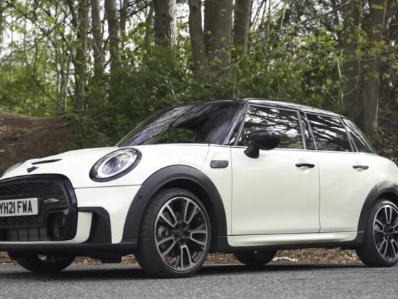 Bijeli Mini Cooper parkiran na cesti