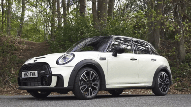 Bijeli Mini Cooper parkiran na cesti