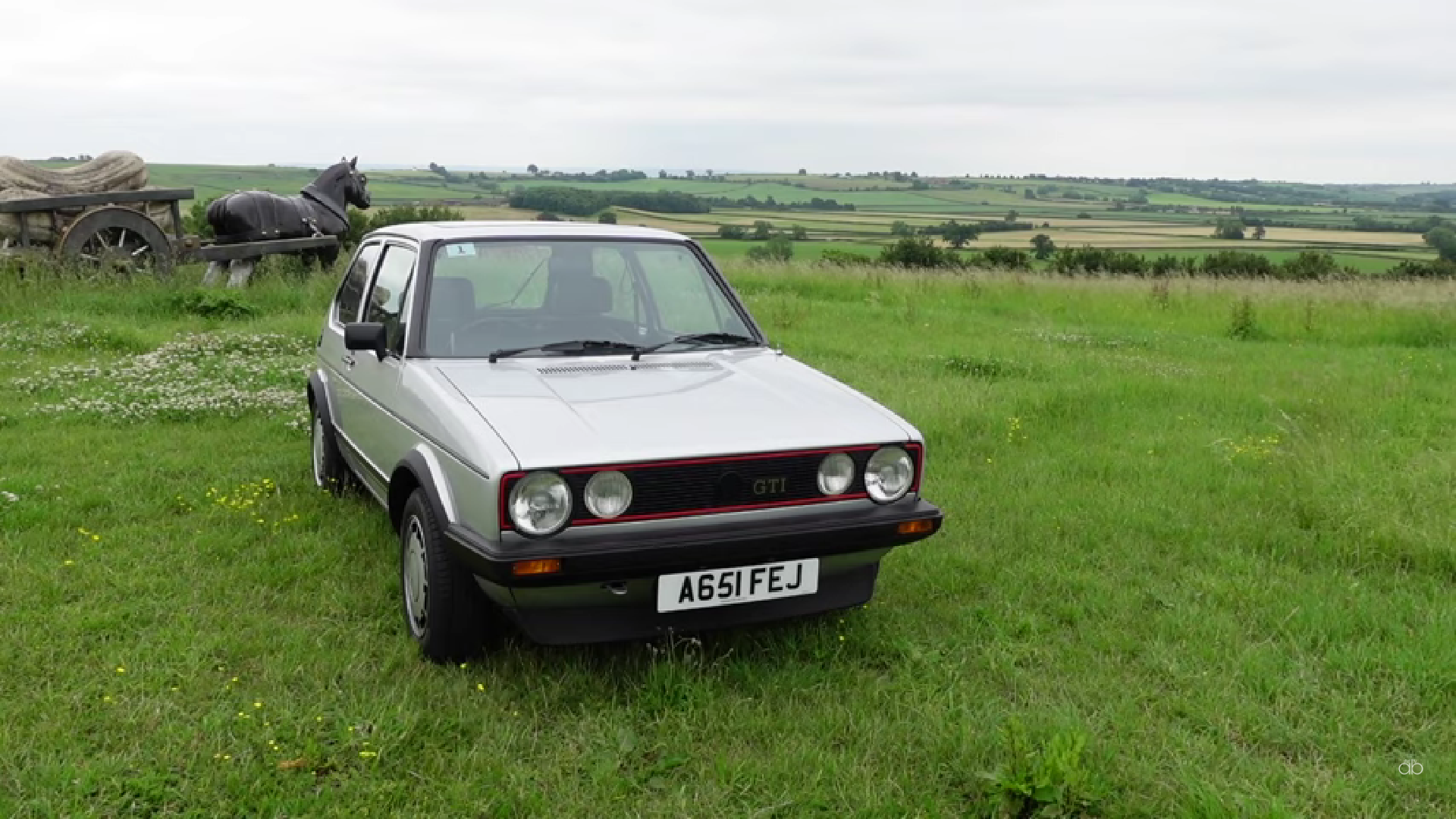 Srebrni Volkswagen Golf 1 parkiran na zelenoj livadi